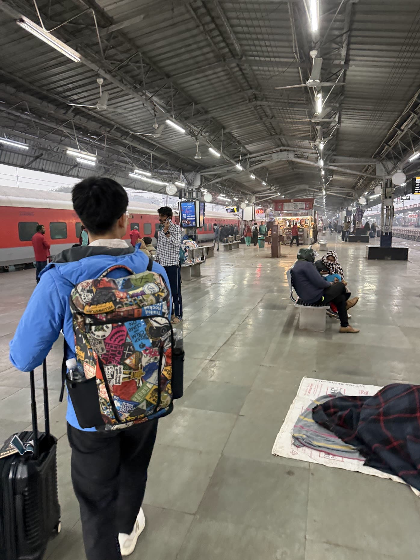 The long covered platform at Agra's train station, with a red train waiting on one side