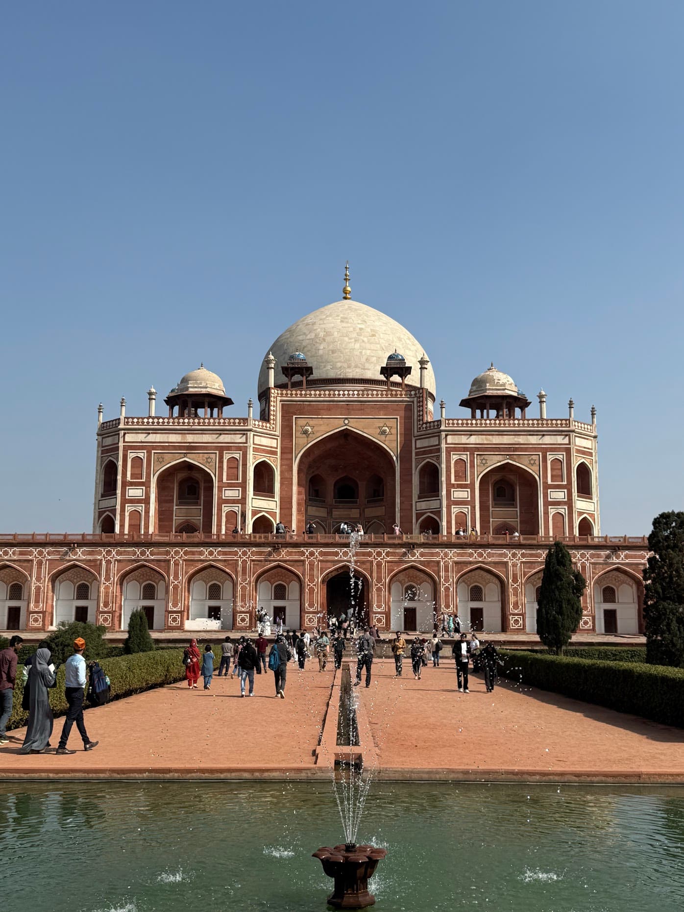 Humayun's Tomb in Delhi, its white dome above red sandstone arches, with a fountain in the foreground