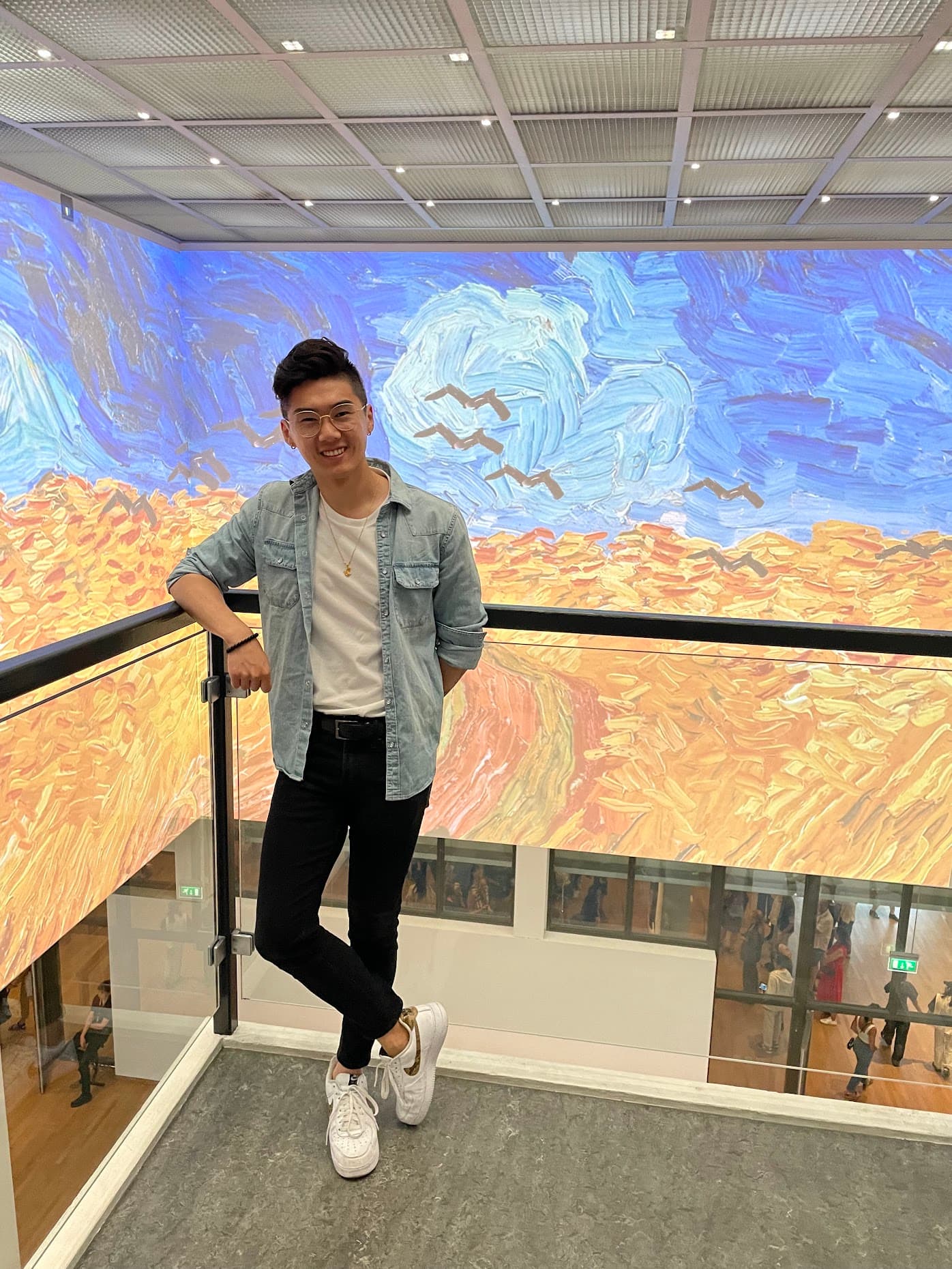 Standing on a balcony inside the Van Gogh Museum with Wheatfield with Crows projected across the surrounding walls